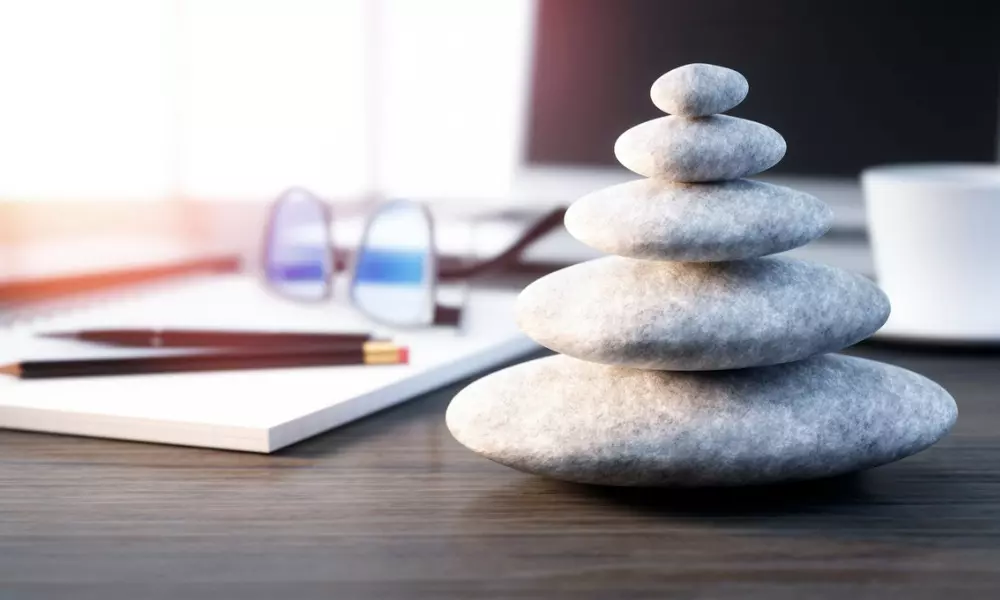 A smiling businessman holds out a handful of rocks.