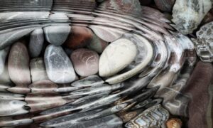 Water ripples over a group of rocks in a stream.