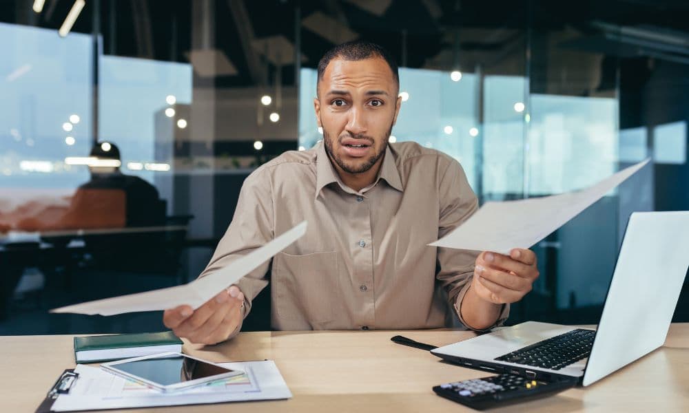 Frustrated leader reviews documents in office.